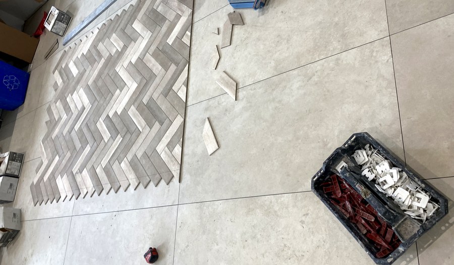 Herringbone pattern floor tile being precisely laid out during a Hamilton bathroom renovation