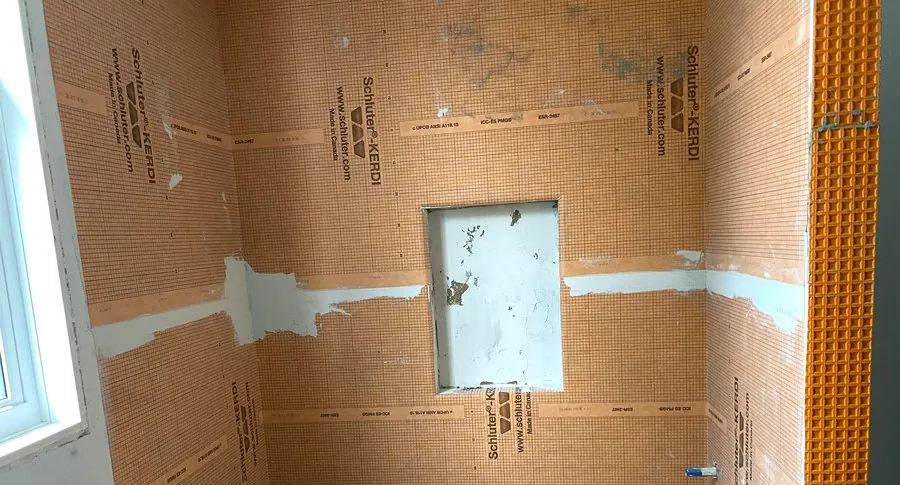 Schluter-Kerdi waterproofing membrane installed with a built-in shower niche before tiling, Hamilton bathroom renovation