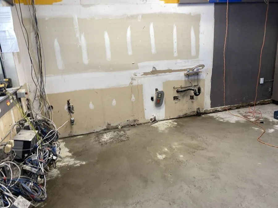 Commercial space in Hamilton after tile demolition and chipping, down to bare concrete slab and stripped walls