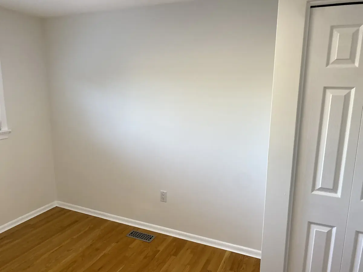 Freshly painted bedroom wall and white trim in a Hamilton home