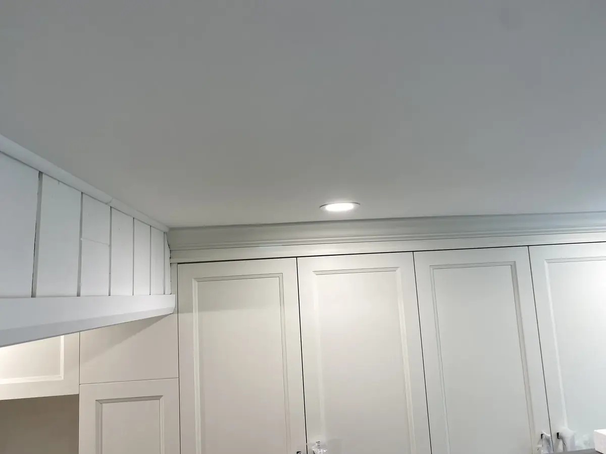 Freshly painted ceiling and white cabinetry in an interior renovation