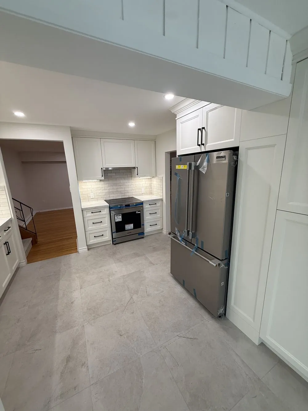 Renovated Ancaster kitchen with new flooring, finished walls and a new stainless fridge