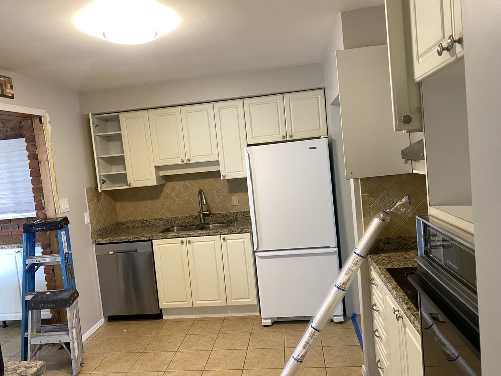 Dated Ancaster kitchen before renovation, with cream cabinetry, laminate countertop and tile backsplash