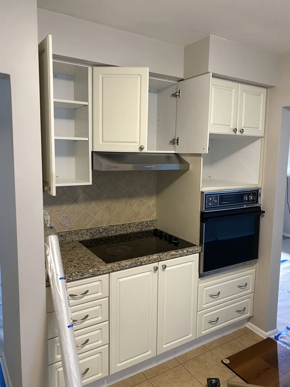 Original Ancaster kitchen cooking nook before renovation, with an old cooktop, built-in wall oven and dated tile