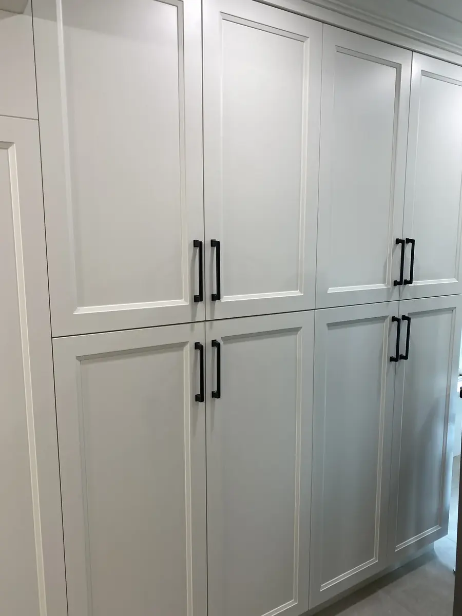 Tall white kitchen cabinets with black handles in a Hamilton renovation