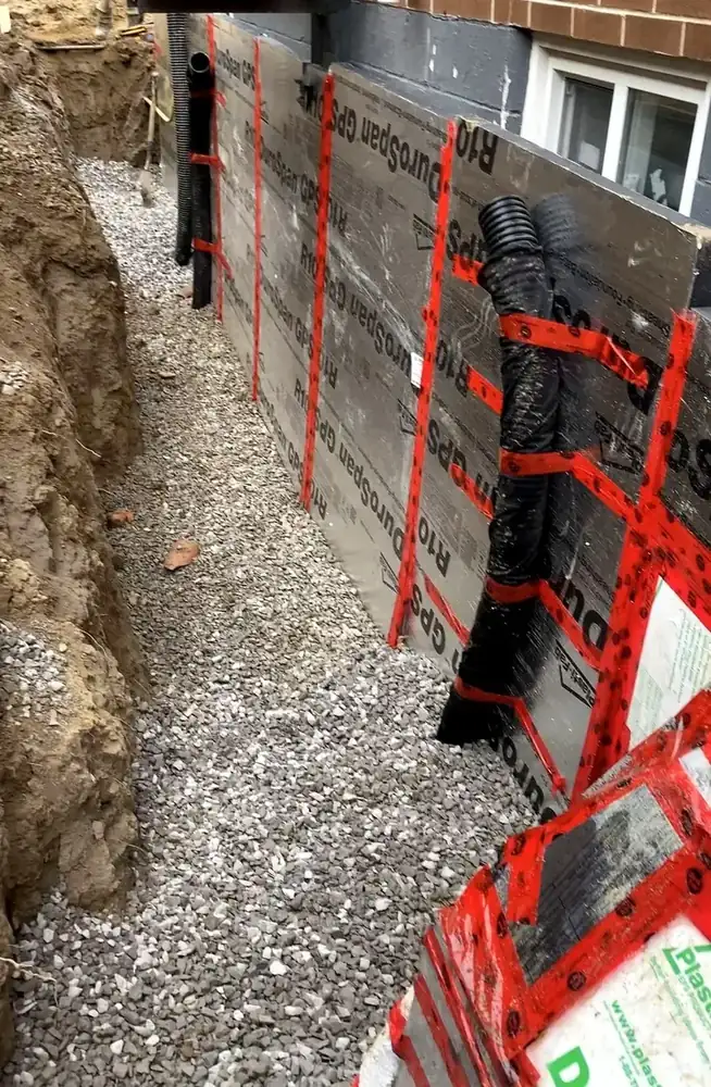 Exterior foundation waterproofing membrane and insulation panels installed on a Hamilton home