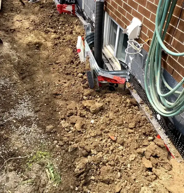 Weeping tile drainage pipe installed at the foundation footing during exterior basement waterproofing, Hamilton